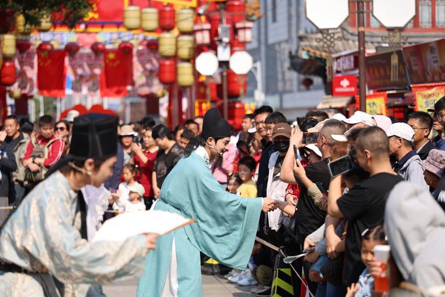 Tourists interact with actors at Yangliuqing ancient town in Tianjin, north China, Oct. 3, 2026. (Xinhua/Li Ran)