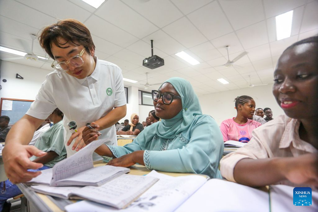 Chinese volunteer teacher Liu Mu guides a student during a class at the Confucius Institute at the University of Dar es Salaam in Dar es Salaam, Tanzania, Oct. 1, 2026.As the world prepares to mark World Teachers' Day on Oct. 5, Chinese and Tanzanian educators are joining forces to expand Chinese language education in Tanzania, blending native linguistic expertise with localized cultural insights. (Xinhua/Emmanuel Herman)