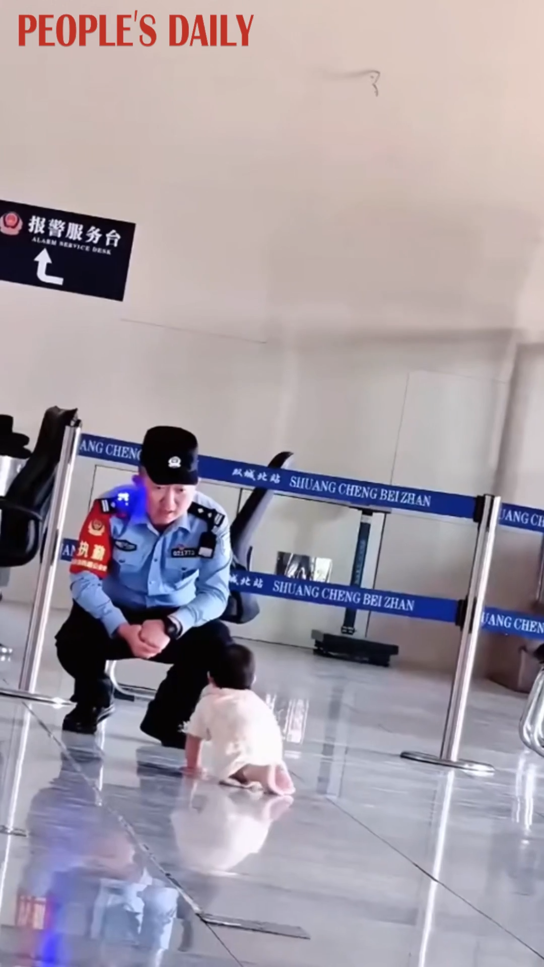 So sweet! Baby crawls over for a hug with police officer at Harbin railway station