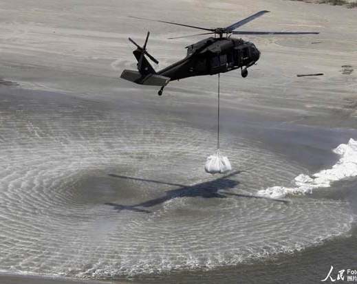 U.S. aircraft airdrops sandbags to curb oil spreading   