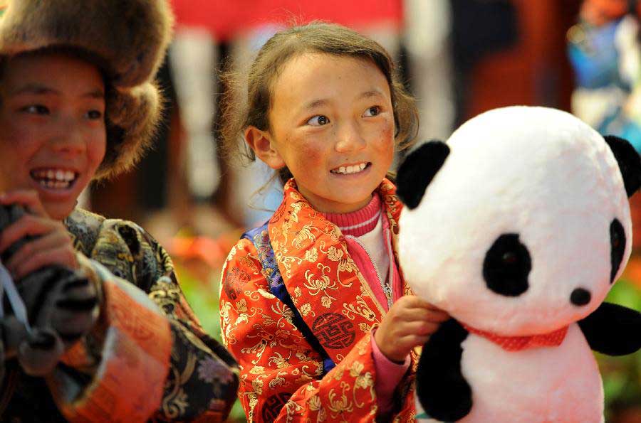 A girl of Tibet ethnic group who is diagnosed with congenital heart disease (CHD) holds a panda doll as she arrives in Hefei, capital of east China's Anhui Province, Nov. 5, 2012. A total of 22 CHD children from China's Tibet Autonomous Region were brought to Anhui for a free medical treatment on Monday. (Xinhua/Liu Junxi) 