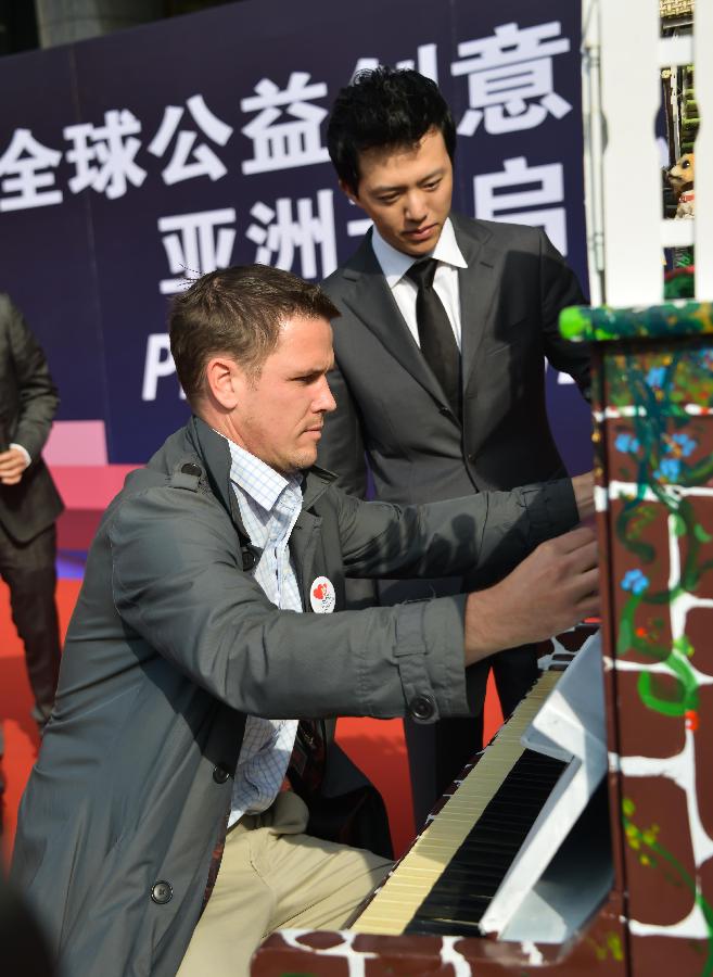 Famous young pianist Li Yundi (R) and British artist Luke Jerram participate in the launch ceremony of a public benefit activity in Hangzhou, capital of east China's Zhejiang Province, Nov. 5, 2012. (Xinhua/Xu Yu)