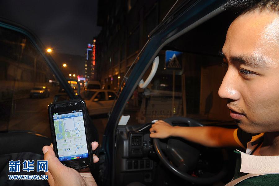 A driver is searching for parking information using his mobile phone at Wangfujing Street in downtown Beijing on July 5. (Photo/ Xinhua)