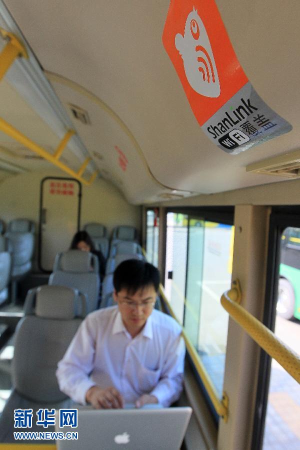 A young man is suffering on the Internet on a bus with WiFi connection in Tianjin on October 11. (Photo/ Xinhua)