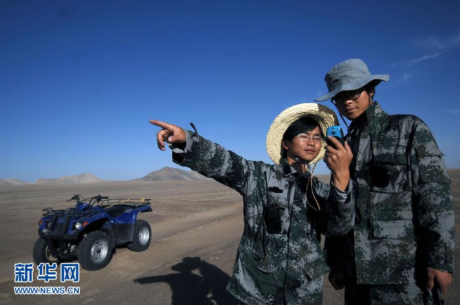 Young geologist Peng Zhongfa locates his position with a GPS device in Golmud of Qinghai province on October 9. (Photo/ Xinhua)