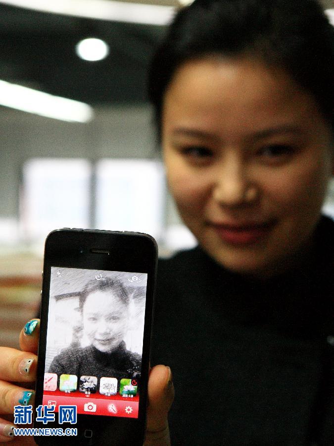 Lu Manman, a developer presents a mobile application for taking photos in Hefei, Anhui province on October 30. (Photo/ Xinhua)