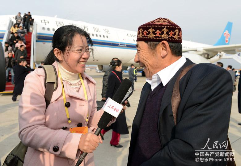 A delegate (R) to the 18th National Congress of the Communist Party of China (CPC) from northwest China's Xinjiang Uygur Autonomous Region, speaks to a reporter upon arrival in Beijing, capital of China, Nov. 5, 2012. The 18th CPC National Congress will be opened in Beijing on Nov. 8. (People's Daily Online/Lei Sheng)