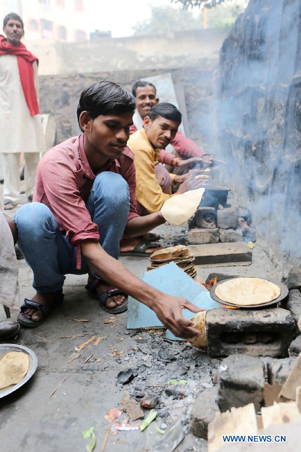A rickshaw driver bakes chapati for breakfast in East Patel Nagar, northern New Delhi, India, on Nov. 5, 2012. Rickshaw drivers' life is hard in the old city of New Delhi. (Xinhua/Li Yigang) 