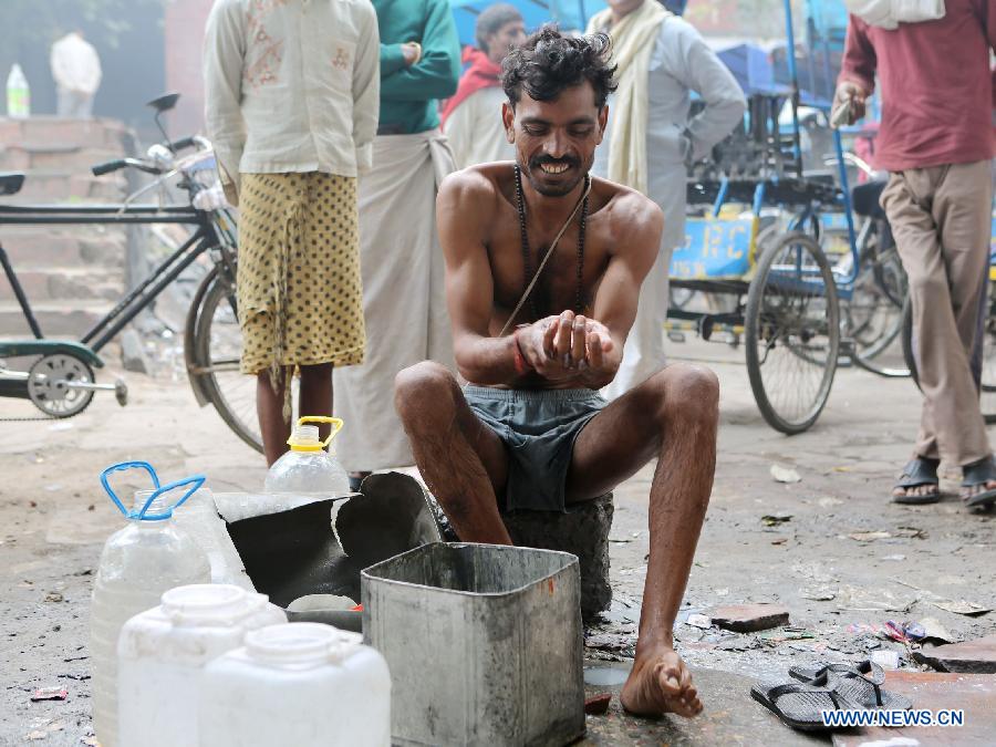 A rickshaw driver takes a bath in East Patel Nagar, northern New Delhi, India, on Nov. 5, 2012. Rickshaw drivers' life is hard in the old city of New Delhi. (Xinhua/Li Yigang) 
