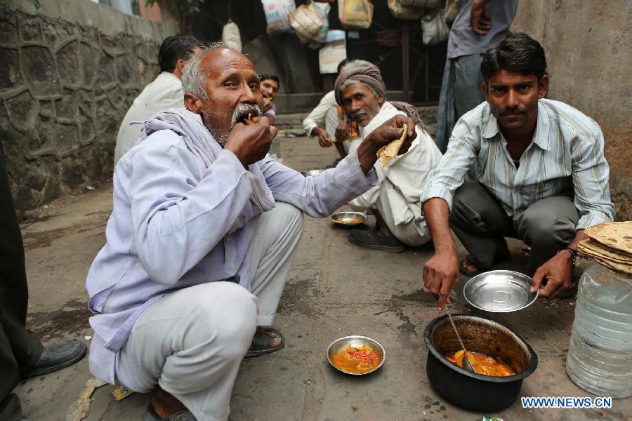 Rickshaw drivers have their breakfast in East Patel Nagar, northern New Delhi, India, on Nov. 5, 2012. Rickshaw drivers' life is hard in the old city of New Delhi. (Xinhua/Li Yigang) 