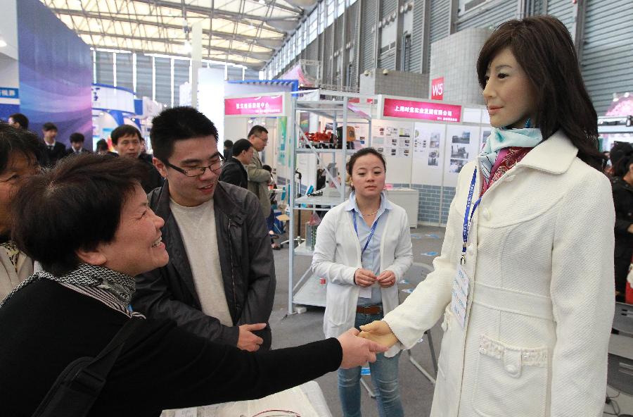 A visitor interacts with a robot during the 14th China International Industry Fair in east China's Shanghai Municipality, Nov. 6, 2012. The industry fair opened to the public Tuesday at Shanghai New International Expo Center, with 1,648 exhibitors from at home and abroad. (Xinhua/Pei Xin)