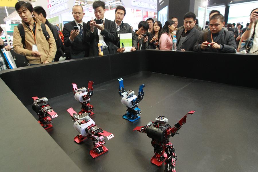 Visitors look at robots dancing during the 14th China International Industry Fair in east China's Shanghai Municipality, Nov. 6, 2012. The industry fair opened to the public Tuesday at Shanghai New International Expo Center, with 1,648 exhibitors from at home and abroad. (Xinhua/Pei Xin) 
