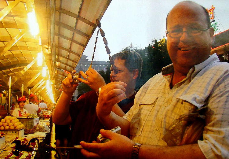 Foreign tourists enjoy traditional Chinese snacks at a night fair in Beijing.(People's Daily Online/ Jiang Jianhua)