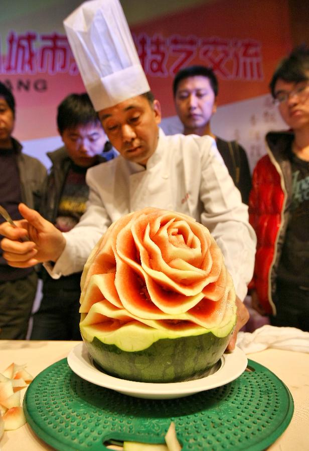 A chef performs cooking skills during a cooking skill exchange activity in Zhenjiang City, east China's Jiangsu Province, Nov. 6, 2012. The exchange activity, launched by restaurant associations from eight cities of Jiangsu Province along the Yangtze River, opened here on Tuesday. (Xinhua/Xu Peiqin)