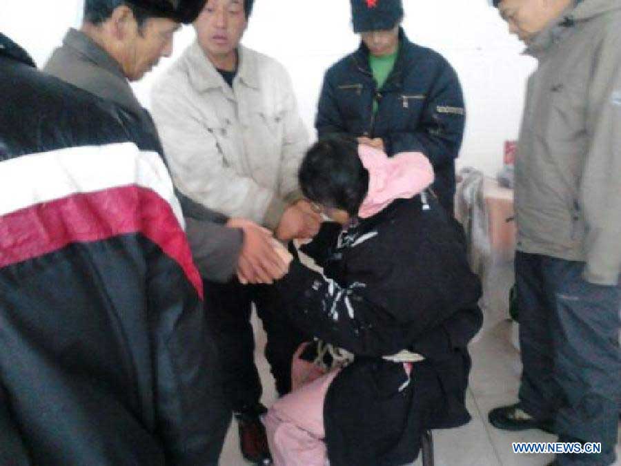 Photo taken by a mobile phone shows a rescuer warming hands for a Japanese tourist after she was saved from a snowstorm in north China's Hebei Province, Nov. 4, 2012. Four Japanese tourists, accompanied by a Chinese tour guide, became trapped by a snowstorm on a snow-covered mountain in Hebei on Nov. 3. Three Japanese tourists who went missing have been confirmed dead, local authorities said Monday. (Xinhua) 