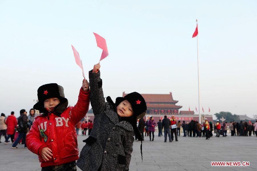 Six-year-old Liu Zetao (R) and five-year-old Yuan Mingxi from east China's Shandong Province pose for photos at the Tian'anmen Square in Beijing, capital of China, Nov. 7, 2012. Tourists from across the country and local residents watched the national flag-raising ceremony at the square early Nov. 7, one day ahead of the opening of the 18th National Congress of the Communist Party of China. (Xinhua/Jin Liwang)