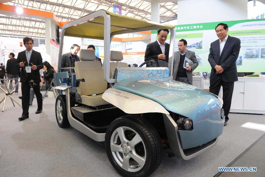 Visitors watch an electric mini-car at the 2012 China International Industry Fair in east China's Shanghai Municipality, Nov. 6, 2012. The industry fair, with the participation of 63 colleges displaying a lot of scientific projects including 51 major technological achievement projects, was open to the public on Tuesday. (Xinhua/Lai Xinlin)