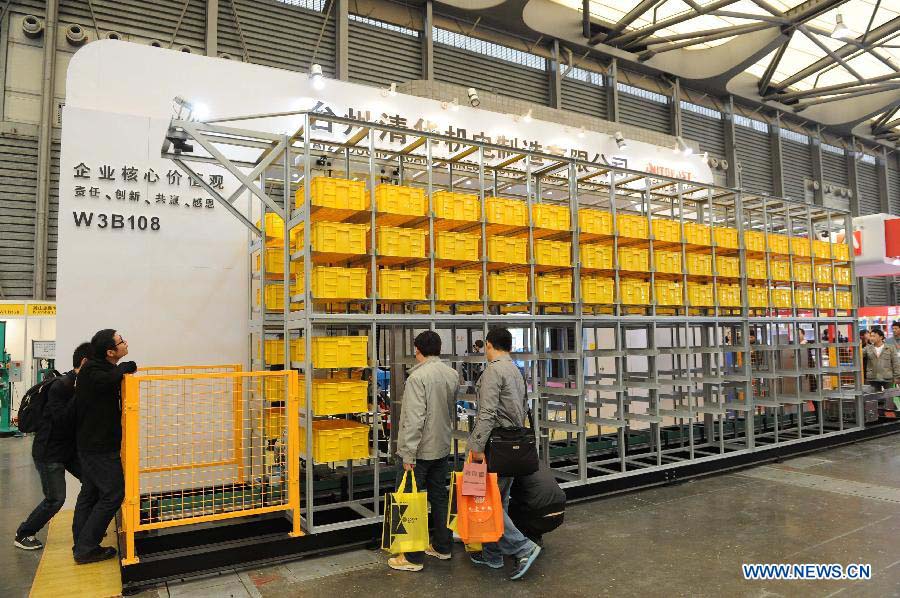 Visitors watch an automatic storage system at the 2012 China International Industry Fair in east China's Shanghai Municipality, Nov. 6, 2012. The industry fair, with the participation of 63 colleges displaying a lot of scientific projects including 51 major technological achievement projects, was open to the public on Tuesday. (Xinhua/Lai Xinlin)