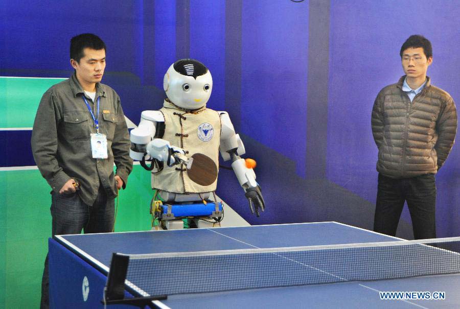 A robot, invented by Zhejiang University, plays table tennis with visitors at the 2012 China International Industry Fair in east China's Shanghai Municipality, Nov. 6, 2012. The industry fair, with the participation of 63 colleges displaying a lot of scientific projects including 51 major technological achievement projects, was open to the public on Tuesday. (Xinhua/Zhu Lan)