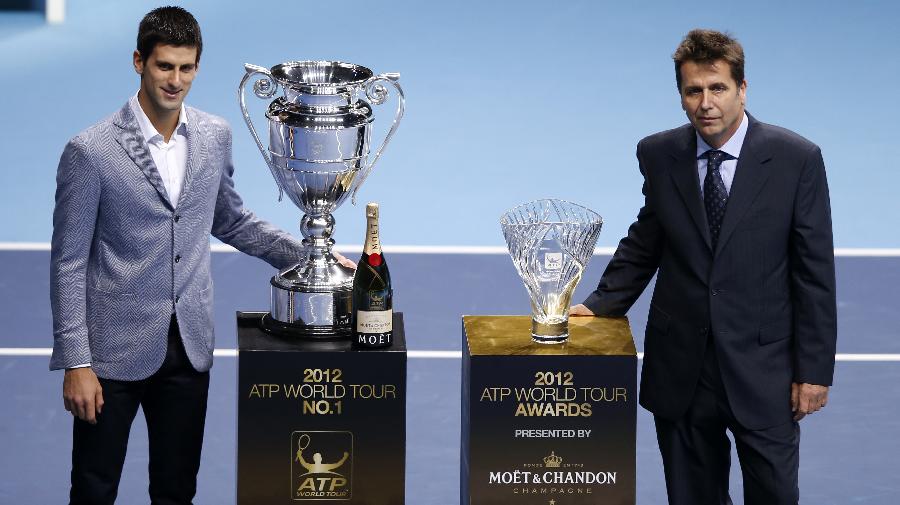 Novak Djokovic of Serbia (L) poses with the trophies of the 2012 ATP World Tour No. 1 Award and the Arthur Ashe Humanitarian Award as ATP executive chairman and president Brad Drewett stands by at the O2 Arena in London, Britain, on Nov. 6, 2012. Djokovic was presented the 2012 ATP World Tour No.1 Award and the Arthur Ashe Humanitarian Award in London Tuesday. (Xinhua/Wang Lili) 