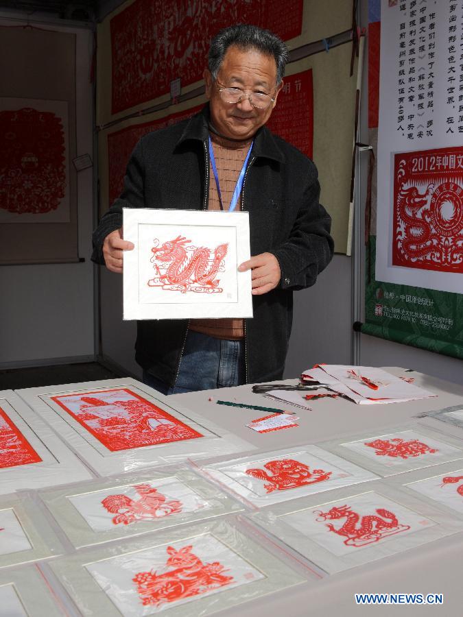 Wang Binghua, an heir to papercutting of east China's Anhui Province, presents a piece of work at the China Huangshan Intangible Cultural Heritage Skills Exposition in Huangshan, east China's Anhui Province, Nov. 7, 2012. A total of 237 Chinese intangible cultural heritage items will be exhibited during the five-day event, which opened here on Wednesday. (Xinhua/Xu Zijian) 