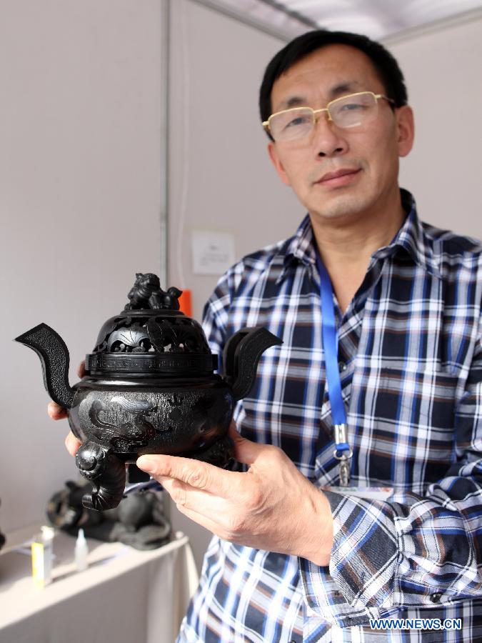 Wang Hongwei, an heir to the coal sculpture techniques of northeast China's Liaoning Province, presents a piece of work at the China Huangshan Intangible Cultural Heritage Skills Exposition in Huangshan, east China's Anhui Province, Nov. 7, 2012. A total of 237 Chinese intangible cultural heritage items will be exhibited during the five-day event, which opened here on Wednesday. (Xinhua/Xu Zijian)