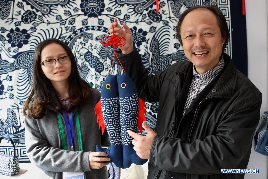 Wu Yuanxin (R) and his daughter Wu Lingshu, who are heirs to the blueprint fabrication of east China's Jiangsu Province, present a piece of work at the China Huangshan Intangible Cultural Heritage Skills Exposition in Huangshan, east China's Anhui Province, Nov. 7, 2012. A total of 237 Chinese intangible cultural heritage items will be exhibited during the five-day event, which opened here on Wednesday. (Xinhua/Xu Zijian)