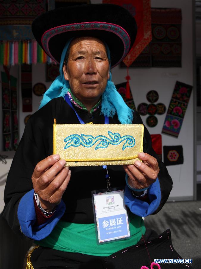 Niu Masu, an heir to the coiled embroidery of the Tu ethnic group in northwest China's Qinghai Province, presents a piece of work at the China Huangshan Intangible Cultural Heritage Skills Exposition in Huangshan, east China's Anhui Province, Nov. 7, 2012. A total of 237 Chinese intangible cultural heritage items will be exhibited during the five-day event, which opened here on Wednesday. (Xinhua/Xu Zijian)