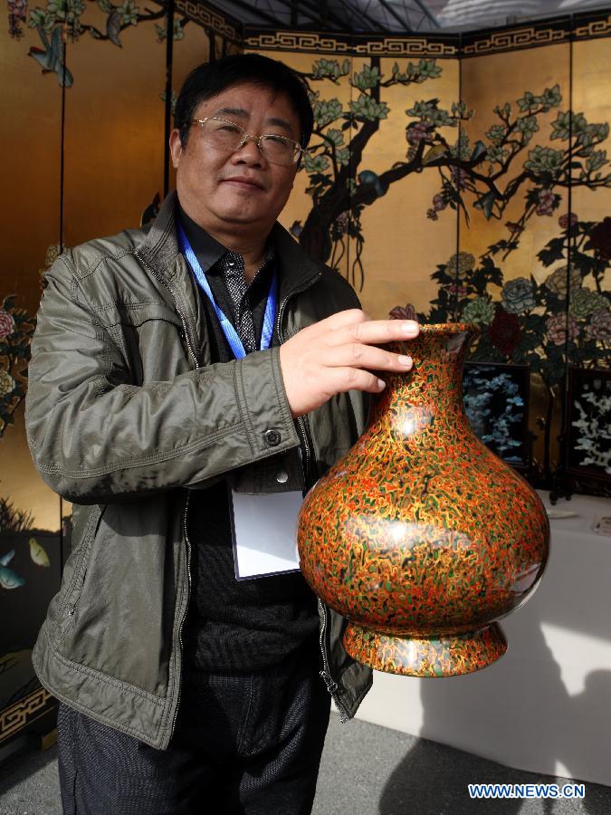 Xi Jianhui, an heir to the lacquering techniques of east China's Anhui Province, presents a lacquered vase at the China Huangshan Intangible Cultural Heritage Skills Exposition in Huangshan, east China's Anhui Province, Nov. 7, 2012. A total of 237 Chinese intangible cultural heritage items will be exhibited during the five-day event, which opened here on Wednesday. (Xinhua/Xu Zijian)