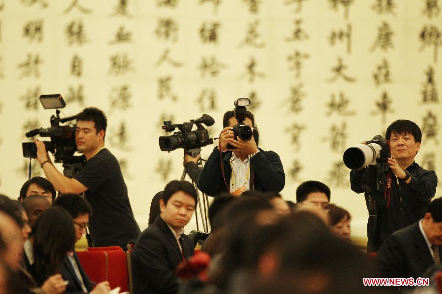 Photographers and cameramen are seen working at the first press conference of the 18th National Congress of the Communist Party of China (CPC) at the Great Hall of the People in Beijing, capital of China, Nov. 7, 2012. The 18th CPC National Congress will be opened in Beijing on Thursday. (Xinhua/Jin Liwang)