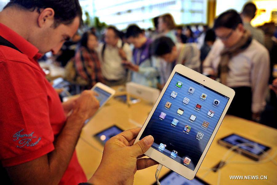 Customers choose iPad minis in an Apple products store in south China's Hong Kong, Nov. 7, 2012. Apple products like iPhone 5, iPad mini sell well after they appeared on the market in Hong Kong in September last year.(Xinhua/Chen Xiaowei) 