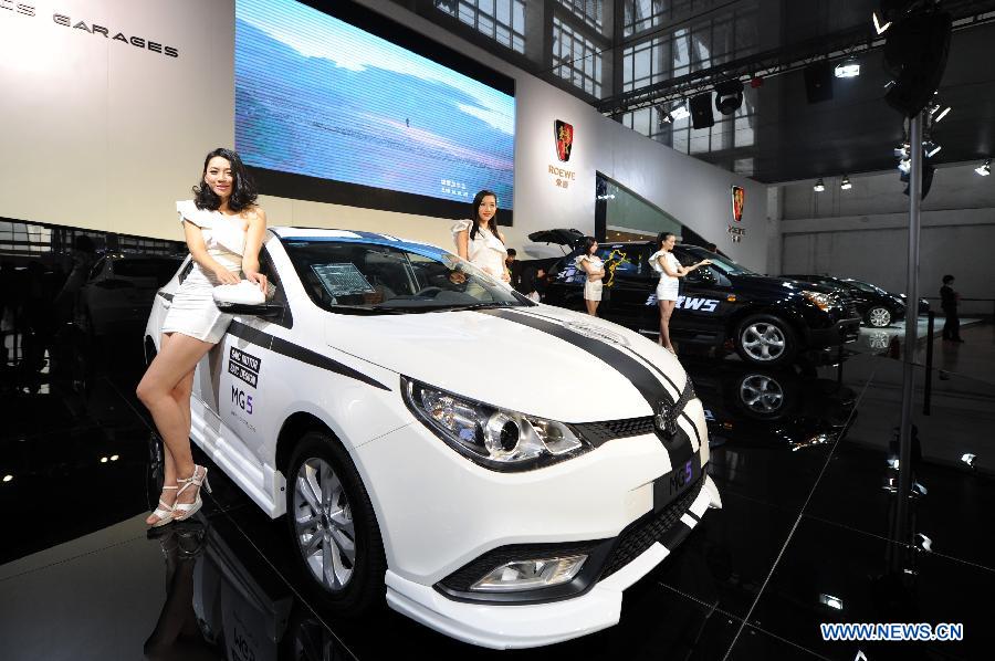 Models present a Roewe MG 5 at the 13th International Automobile Industry Exhibition in Hangzhou, capital of east China's Zhejiang Province, Nov. 7, 2012. The five-day exhibition, which kicked off on Wednesday, displays vehicles of 60 brands from both home and abroad. (Xinhua/Ju Huanzong)