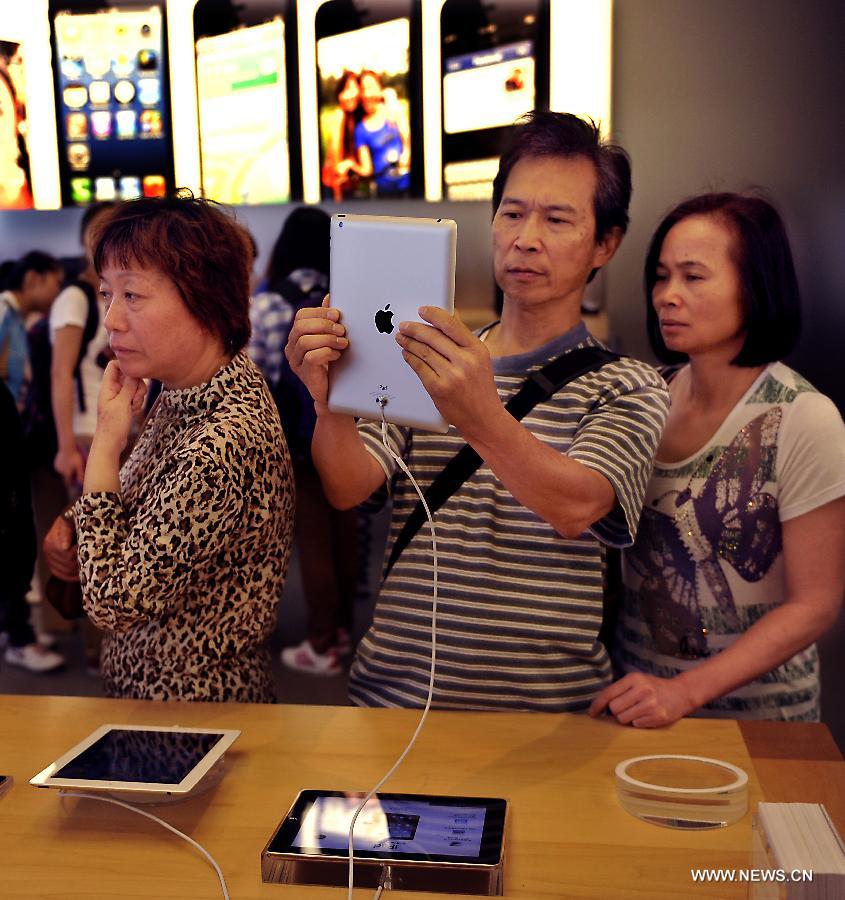 Customers choose iPads in an Apple products store in south China's Hong Kong, Nov. 7, 2012. Apple products like iPhone 5, iPad mini sell well after they appeared on the market in Hong Kong in September last year.(Xinhua/Chen Xiaowei) 