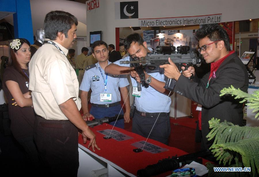 Visitors check rifles on display during the five-day International Defense Exhibition at the expo center in southern Pakistani port city of Karachi, Nov. 7, 2012. A total of 135 foreign and 74 Pakistani firms participated in the international defense exhibition which kicked off here on Wednesday. (Xinhua)