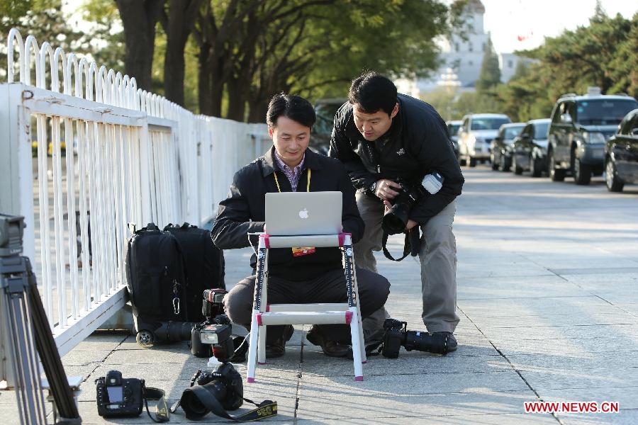 Xinhua photographers Xie Huanchi (L) and Wang Ye work during their coverage of the 18th National Congress of the Communist Party of China (CPC) at the Tian'anmen Square in Beijing, capital of China, Nov. 8, 2012. The 18th CPC National Congress opened in Beijing on Thursday, which also marks the 12th Journalists' Day of China. A total of 2,732 Chinese and foreign journalists are involved in the coverage of the 18th CPC National Congress. (Xinhua/Xing Guangli)