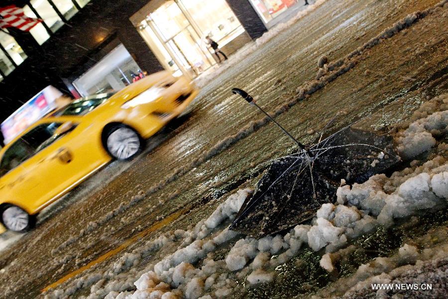 A taxi is driven by a broken umbrella on the 5th Avenue in New York, the United States, Nov. 7, 2012. As New Jersey and New York are still trying to recover from the damage created by Hurricane Sandy, a Nor'easter named Winter Storm Athena dropped snow and rain on the Northeast on Wednesday, also bringing dangerous winds and knocking out power. (Xinhua/Wu Jingdan)