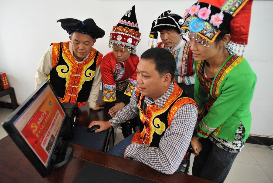 Staff members of the township government browse the website of Xinhuanet to read live media reports on the opening ceremony of the 18th National Congress of the Communist Party of China (CPC) in Lantian Yao Township, Lingchuan County, south China's Guangxi Zhuang Autonomous Region, Nov. 8, 2012. The 18th CPC National Congress was opened in Beijing on Thursday. (Xinhua/Lu Boan)