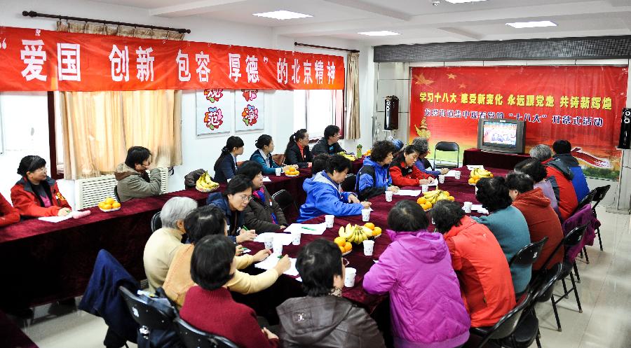 Local residents watch TV reporting the opening ceremony of the 18th National Congress of the Communist Party of China (CPC) in Beijing, capital of China, Nov. 8, 2012. The 18th CPC National Congress was opened in Beijing on Thursday. (Xinhua/Liu Changlong)