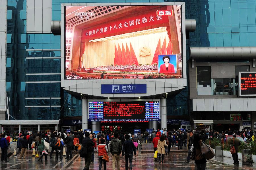 Passengers watch TV reporting the opening ceremony of the 18th National Congress of the Communist Party of China (CPC) at the railway station in Guiyang, capital of southwest China's Guizhou province, Nov. 8, 2012. The 18th CPC National Congress was opened in Beijing on Thursday. (Xinhua/Liu Xu)