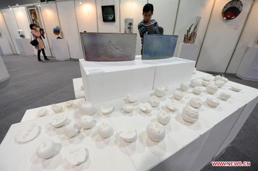 People visit the 15th West Lake Art Fair in Hangzhou, capital of east China's Zhejiang Province, Nov. 8, 2012. The five-day fair, which kicked off on Thursday, attracted more than 200 exhibitors. (Xinhua/Ju Huanzong)