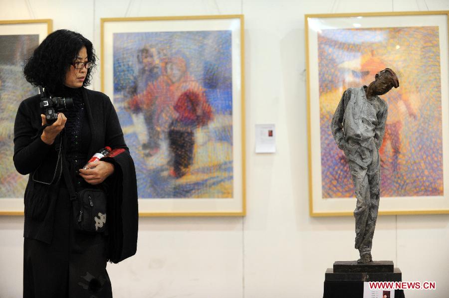 A woman visits the 15th West Lake Art Fair in Hangzhou, capital of east China's Zhejiang Province, Nov. 8, 2012. The five-day fair, which kicked off on Thursday, attracted more than 200 exhibitors. (Xinhua/Ju Huanzong) 