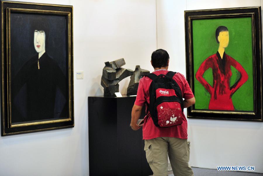 A visitor looks at an art work displayed at the exhibiton "Art Taipei 2012" in Taipei, southeast China's Taiwan, Nov. 8, 2102. "Art Taipei 2012" will take place from Nov. 9 to 12 at Taipei World Trade Center, displaying more than 2,000 art works from 150 galleries of 15 countries and regions. (Xinhua/Wu Ching-teng)