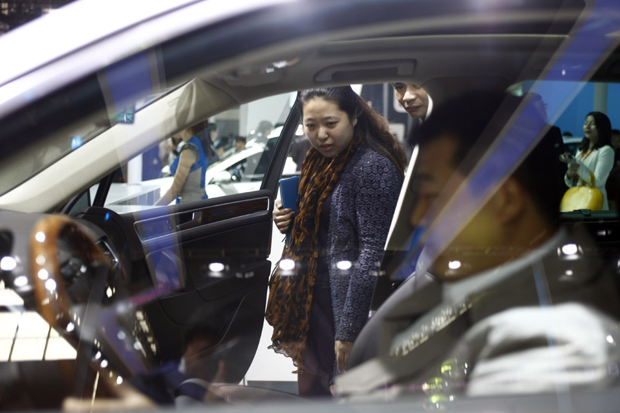 Visitors look at a car displayed at the 13th International Automobile Industry Exhibition in Hangzhou, capital of east China's Zhejiang Province, Nov. 7, 2012. 