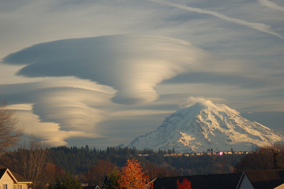 Lenticular Clouds Over Washington. Are those UFOs near that mountain? No -- they are multilayered lenticular clouds. Moist air forced to flow upward around mountain tops can create lenticular clouds. Water droplets condense from moist air cooled below the dew point, and clouds are opaque groups of water droplets. (Photo/ NASA)