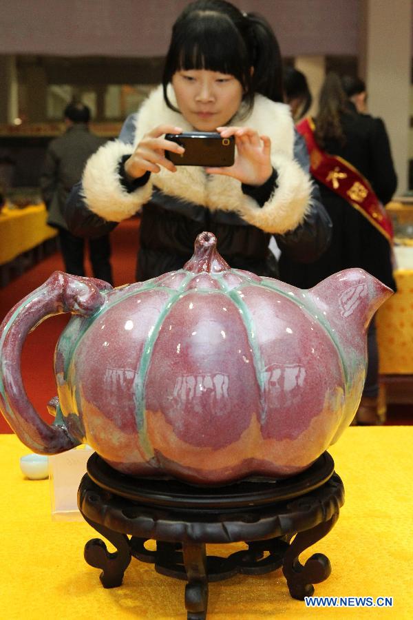 A woman takes pictures of a pot displayed at Henan Jun porcelain pots design competition in Yuzhou City of Xuchang, central China's Henan Province, Nov. 10, 2012. Jun porcelain, one of the five top porcelains in China, is famous for the amazing change of its color during the process of firing in kilns. (Xinhua/Niu Shupei)