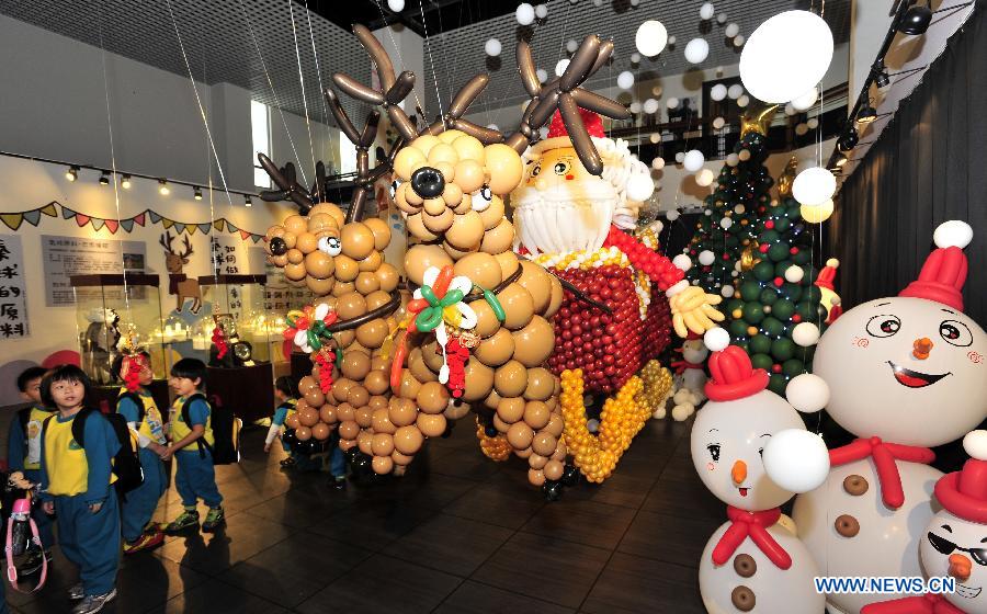 Children view Santa Claus and reindeer made up of balloons during the "BOOMBOOM" Balloon Doll Exhibition at the Puppetry Art Center of Taipei, southeast China's Taiwan, Nov. 9, 2012. (Xinhua/Wu Ching-teng) 