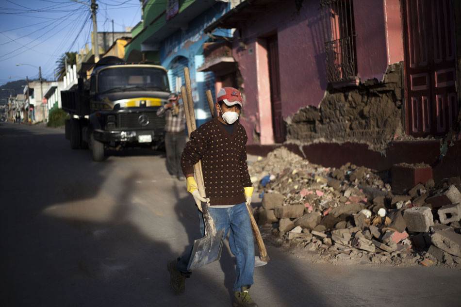 A man is going to repair the roads that are damaged by a 7.4 magnitude earthquake in San Marcos, capital city of Guatemala, on Nov. 8, 2012. (Photo/Xinhua)