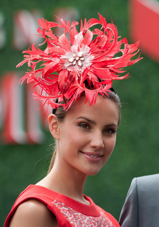 A woman watches horse race with a colorful vintage hat in Melbourne, Australia, Nov. 6, 2012. (Xinhua/Baixue)