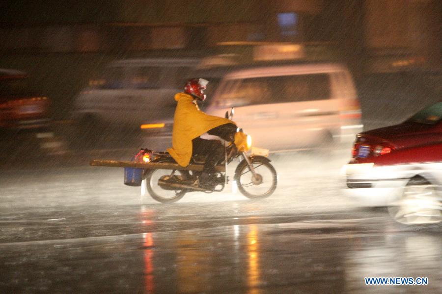A citizen rides a motorcycle in the rain on Beima Road of Yantai City, east China's Shandong Province, Nov. 10, 2012. A strong cold snap brought rainfall and wind to the coastal city, causing a fall in temperature. (Xinhua/Shen Jizhong)