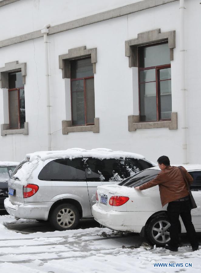 A man sweeps snow off his car in Hohhot, capital of north China's Inner Mongolia Autonomous Region, Nov. 10, 2012. A heavy snowfall hit Hohhot on Nov. 9. (Xinhua/Liu Yide)